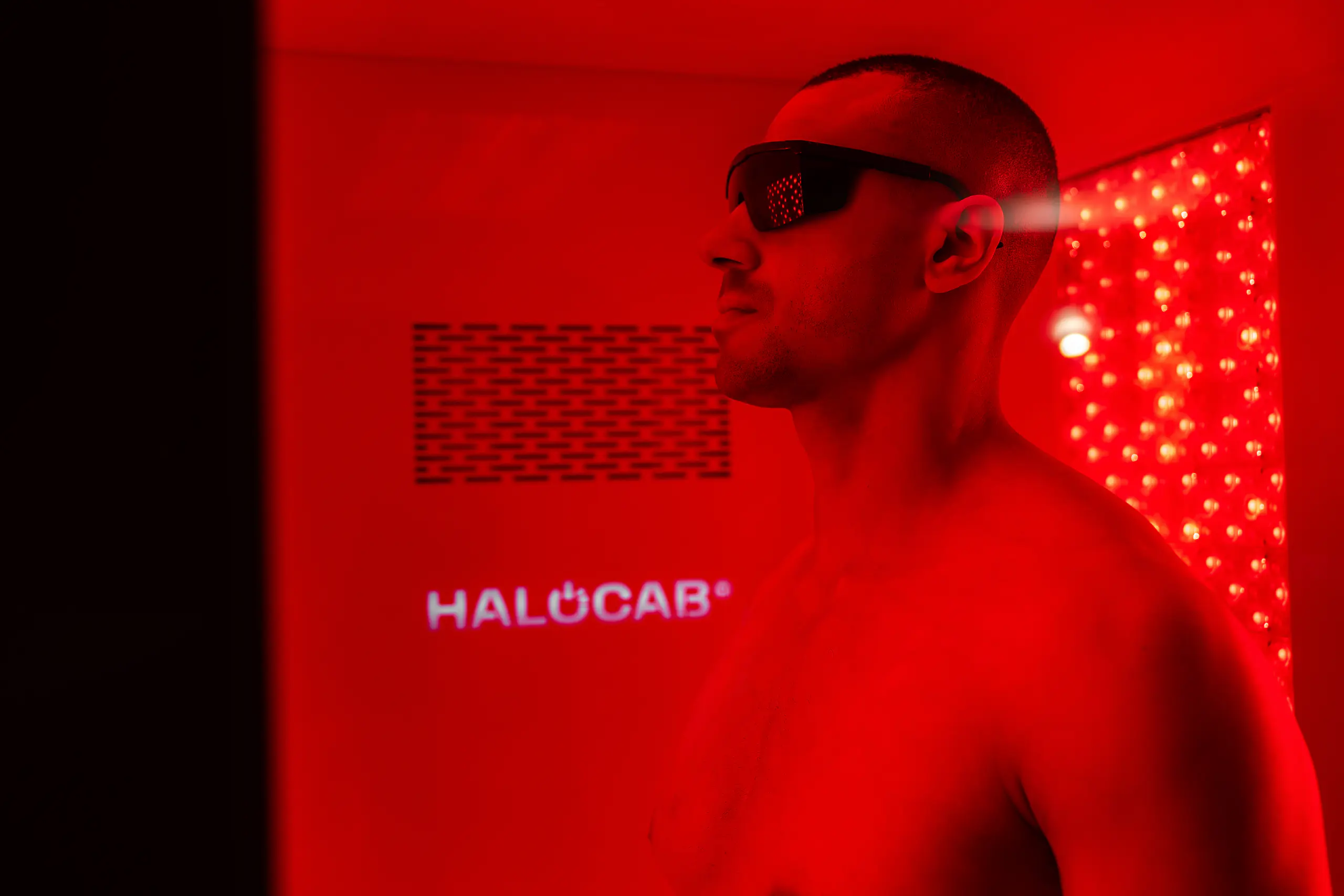 Personne installée dans la cabine Halocab, baignée de lumière rouge